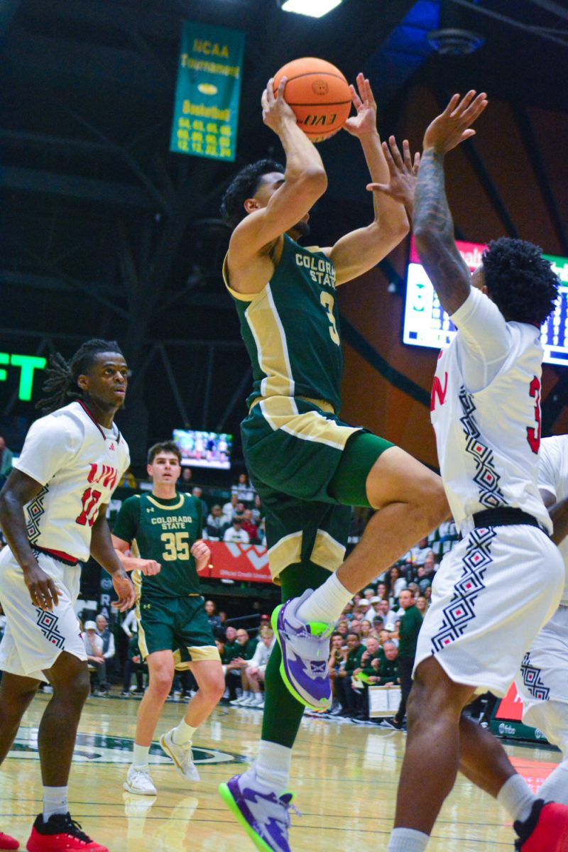 A player in a green and gold jersey making a layup.