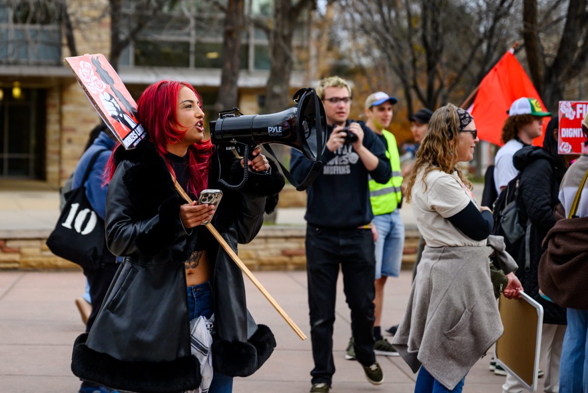 Sophia Johnson chants, "No ICE, no KKK no fascist USA," into a megaphone as people gather on the Lory Student Center Plaza before the March for Academic Freedom Nov. 7.