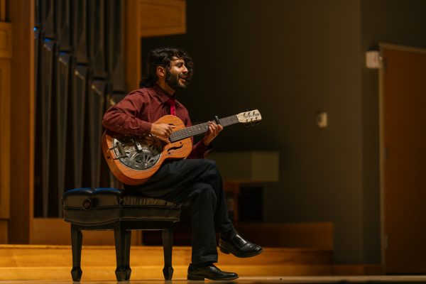 A man sings and plays guitar.