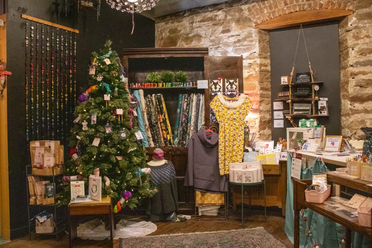 Materials available for purchase sit on a shelf underneath a sign advertising an Open Stitch Night at The Twisted Stitch Nov. 22. The store opened May 1, Nadia Hare said, who is one of the owners.