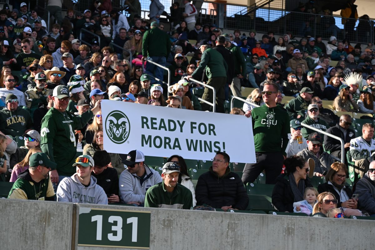 Two fans hold up a sign that reads "Ready for Mora wins!" in the stands of Canvas Stadium during Colorado State University's football game against Air Force Academy Nov. 28. Jim Mora was announced as CSU's new head football coach after the previous head coach, Jay Norvell, was let go midseason. 