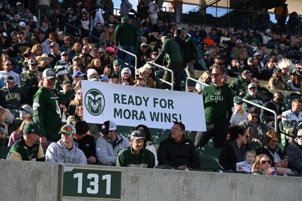 Two fans hold up a sign that reads "Ready for Mora wins!" in the stands of Canvas Stadium during Colorado State University's football game against Air Force Academy Nov. 28. Jim Mora was announced as CSU's new head football coach after the previous head coach, Jay Norvell, was let go midseason. 