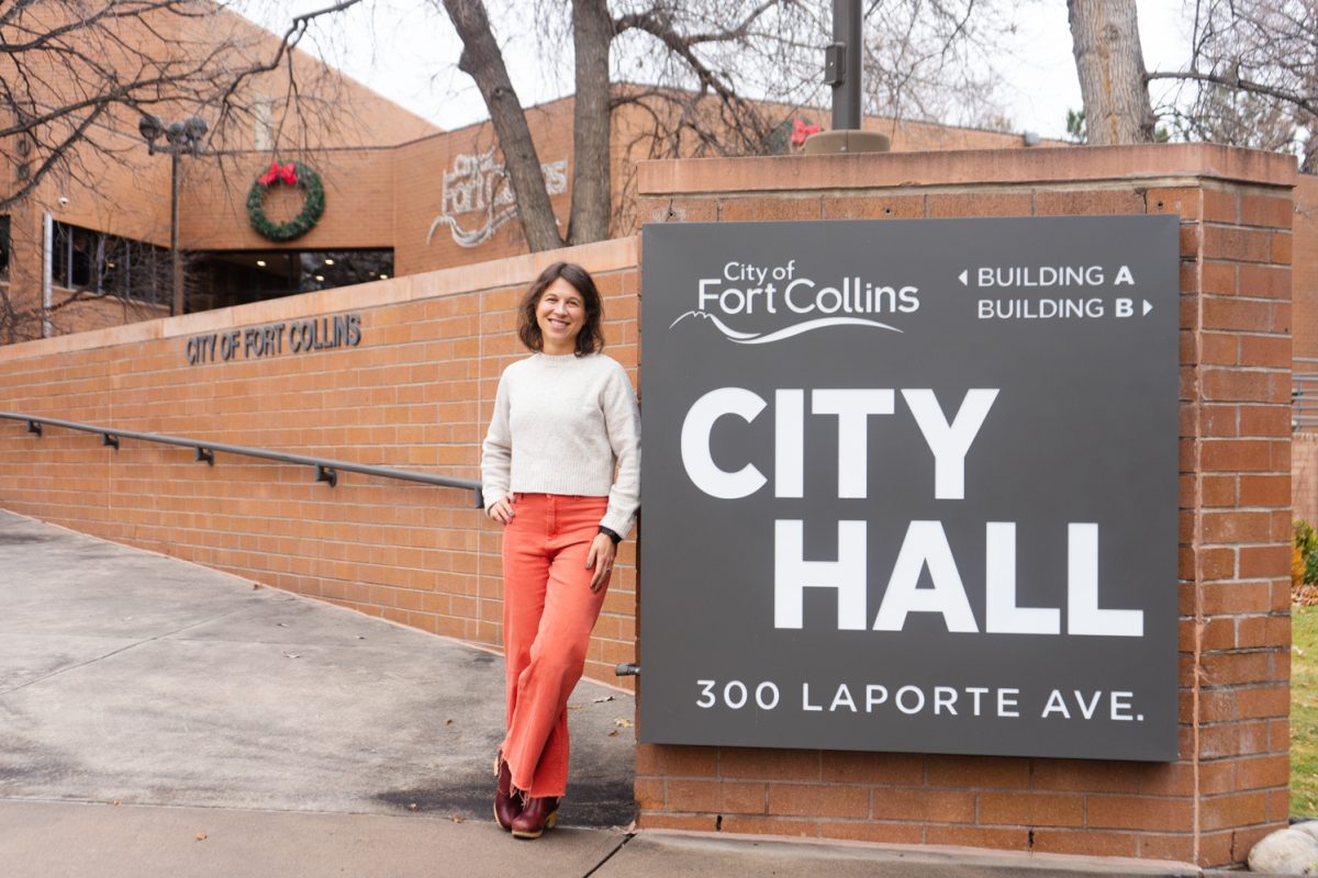 2025 Elected Mayor of the City of Fort Collins Emily Francis poses for a photo next to a large City Hall sign in front of its brick building Nov. 21. “I really just try to think about what is the best thing for our community and the people who live here, and the people who don't have time to show up at city council or don't know you can send an email…” said Francis.