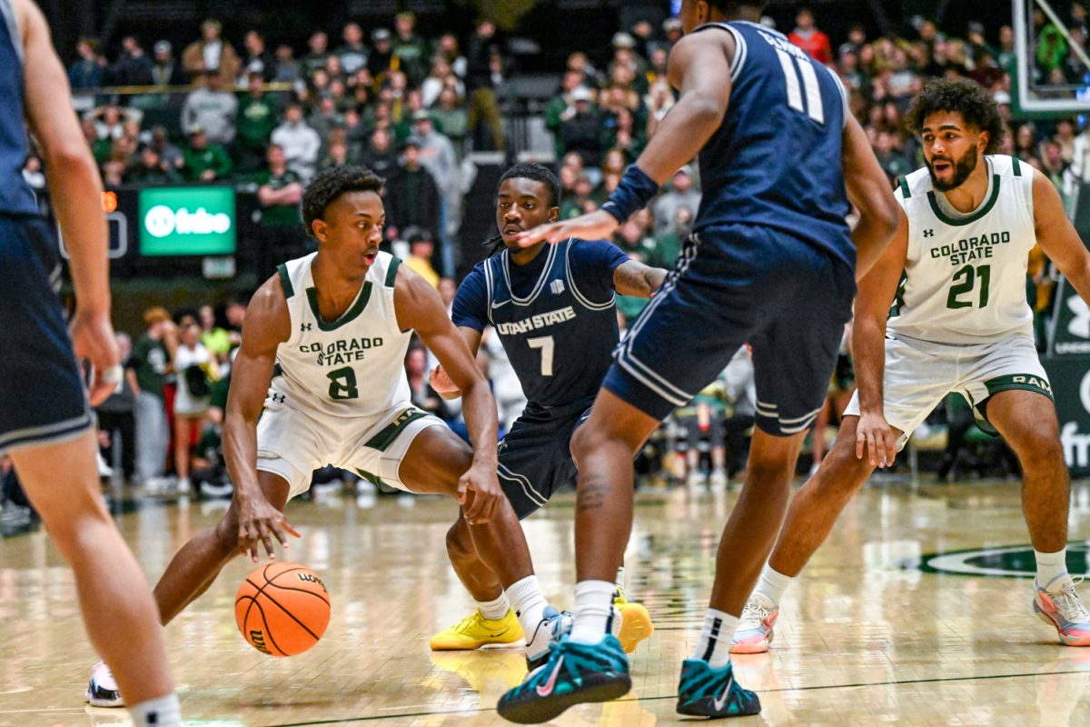 Colorado State University men's basketball guard Jojo McIver (8) avoids Utah State University defenders during CSU's game against UVU Jan. 23.
