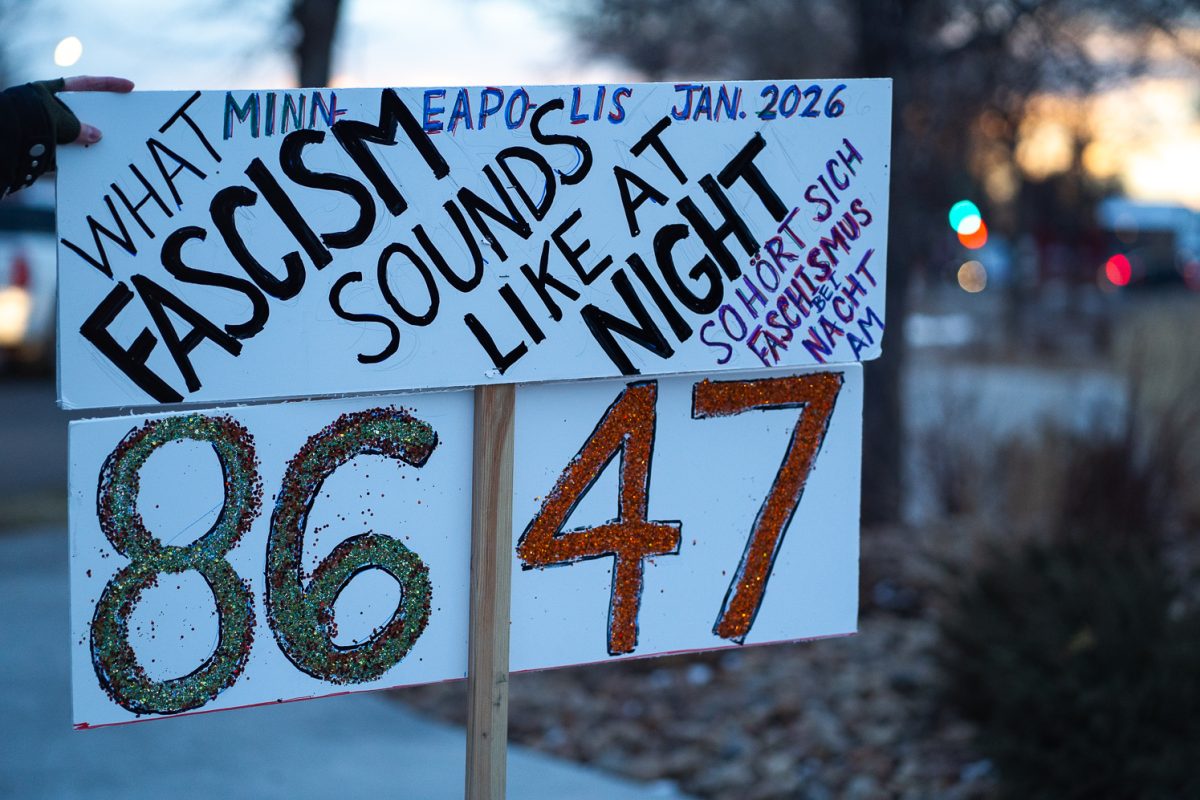 Marcia Kavey holds a sign while participating in a protest on College Avenue just north of Drake Road Tuesday, Jan. 20. The walk-out protest was connected to similar protests across the country. 