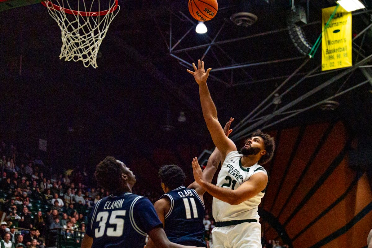 Colorado State University men's basketball forward Rashaan Mbemba (21) pushes through Utah State University's defenders to make a shot during CSU's game against UVU Jan. 23.