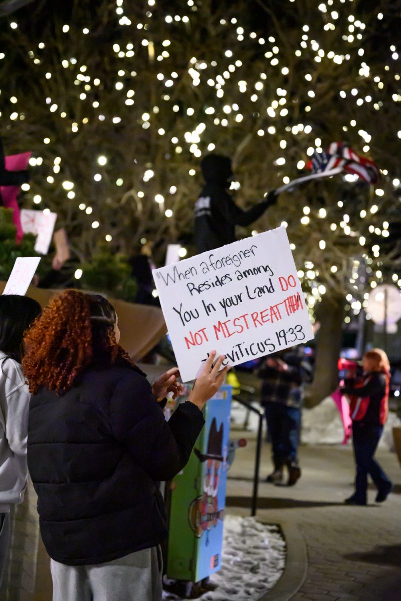 A protestor holds up a sign quoting Leviticus 19:33 during an anti-ICE protest in Old Town Square Jan. 29. The Bible verse discusses treating foreigners with kindness.
