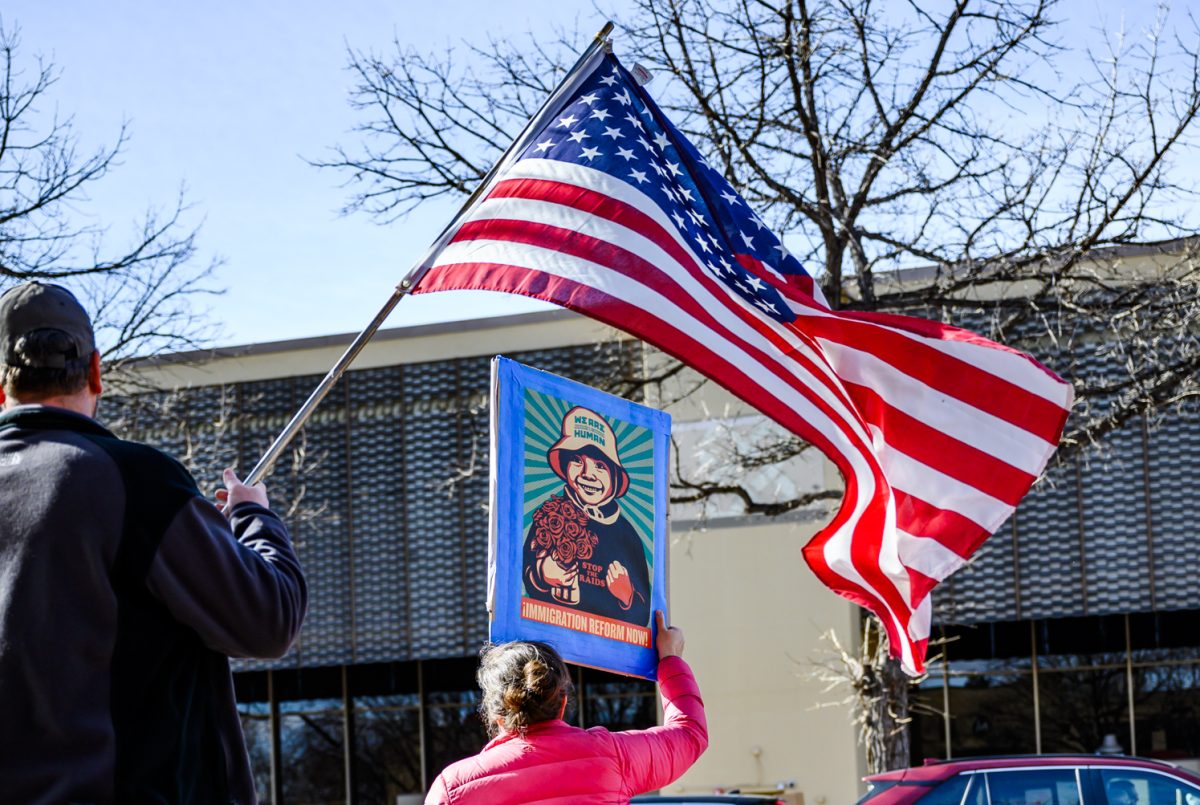 Protesters hold signs and flags to protest the recent actions of ICE and demand reform Jan. 30.