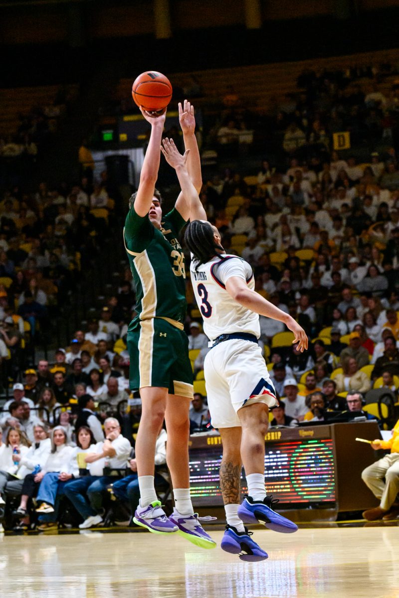 Colorado State University men's basketball forward Kyle Jorgensen attempts a three-point shot while taking pressure from University of Wyoming guard Khaden Bennett Jan. 31.
