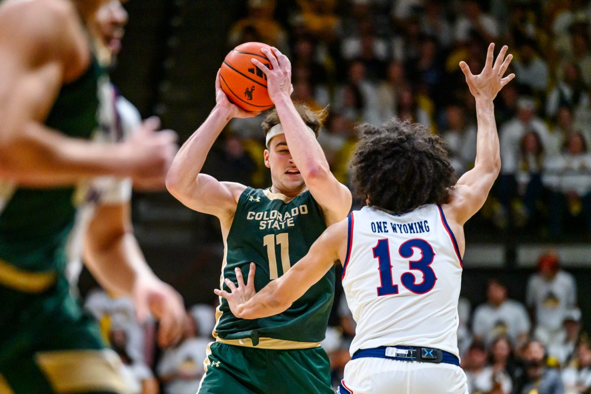 Colorado State University men's basketball forward Augustinas Kiudulas (11) avoids University of Wyoming guard Adam Harakow (13) during CSU's game in UW's Arena-Auditorium Jan. 31.