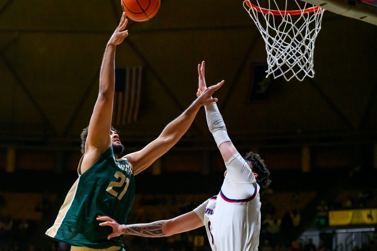 Colorado State University men's basketball forward Rashaan Mbemba (21) makes a shot while facing pressure from University of Wyoming's defense Jan. 31. Mbemba put up six points during the game. 