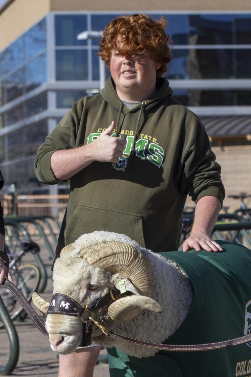 A Colorado State University student poses for a picture with CAM the Ram at his 72nd birthday party. This event was put on at the CSU Student Recreation Center by the Alumni Association. Feb. 7