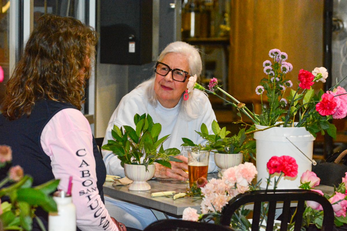 Janet Mahoney and Christine Turner talk while creating flower bouquets Feb. 13. The flower workshop was put on by Breckenridge Brewery. 