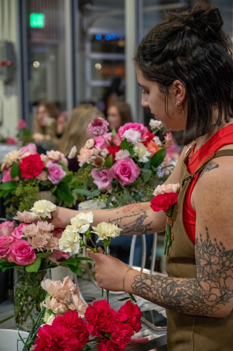 Elcee Evershed pulls extra flowers out of the bucket to add to the flower pin in her overalls Feb. 13. She watches the class as one of two teachers in guiding the Galentines event at Breckenridge Brewery. “Lauren and I do all of our floral classes and we just have a really fun time with it,” Evershed said. “Because it's a little bit different than the flowers we have at the garden center.”
