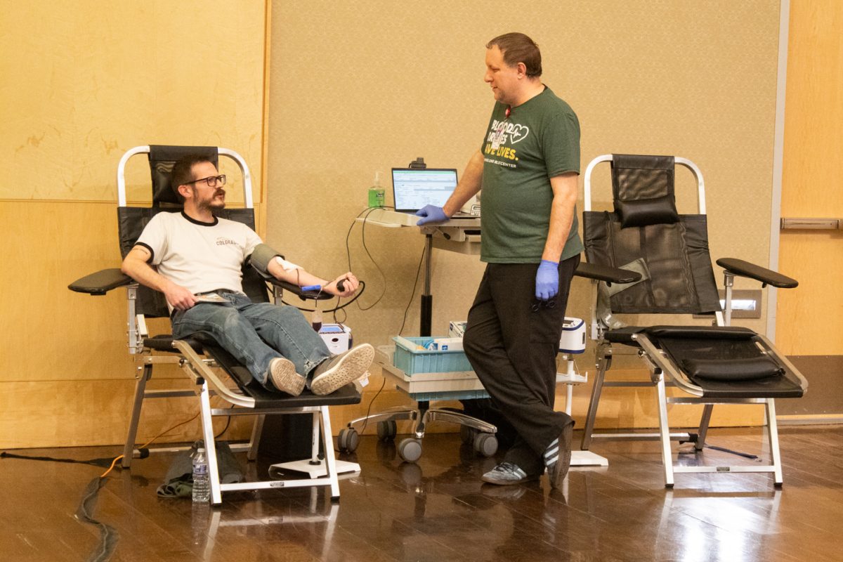 Chris Jeracki, a Colorado State University student, squeezes a blood pressure cuff while donating blood and talking to Joe Dunn, blood drive recruiter for UCHealth, during the Garth Englund Blood Center blood drive in the Lory Student Center Feb. 18. “I’m just actually donating with my mom," Jeracki said. "We like to do things together. It’s a good cause."
