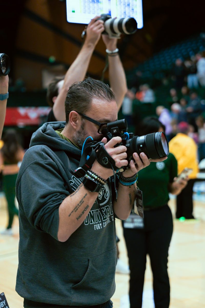Colorado State University alumn John Barnhardt, a documentary videographer, films the CSU women's basketball team as they huddle together after their game against Nevada. CSU won 70-59 on Feb. 18.
