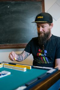 A Mahjong player looks at a tile.