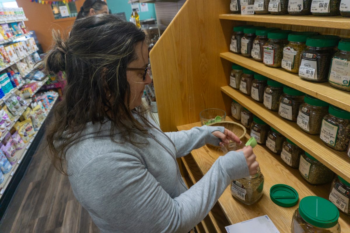 Laurie Gilligan fills a small bag with cumin seed at the newly opened Fort Collins Food Co-Op Feb 22. Gilligan said she used to shop at the old Co-Op location but her grocery needs weren't being met there. "I think they'll have a lot more space here," she said.