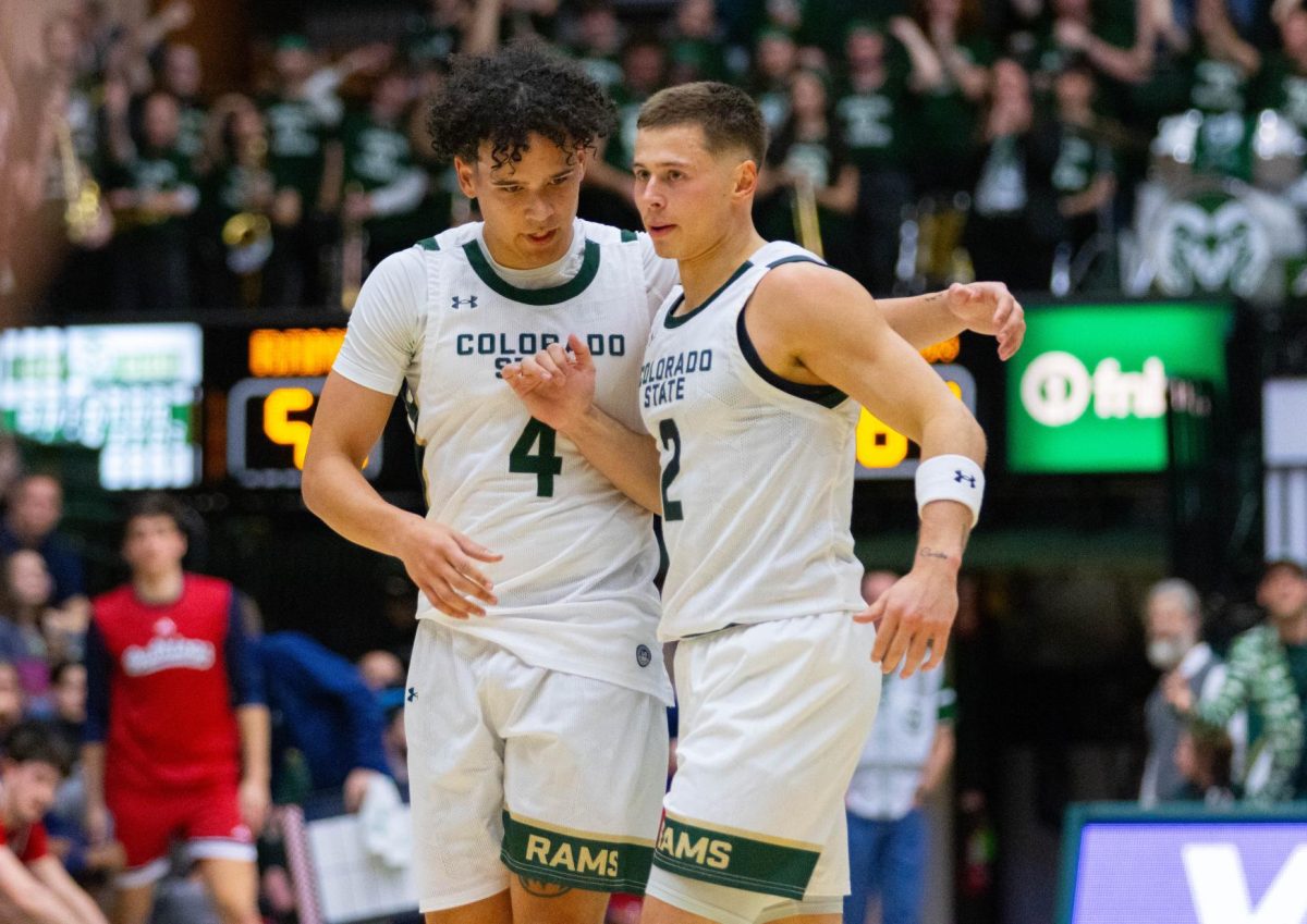 Two men in all white jerseys hug each other.
