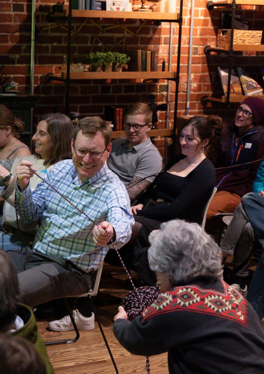 To map out how long the uncoiled DNA would be if taken from a salamander cell, Bill Hoffman and Denise Steffenhagen help hand out an 80 meter ball of yarn for the audience to pass around Feb. 25. “Her examples, her comparisons were awesome,” Steffenhagen said, when asked what her favorite part of the talk was.