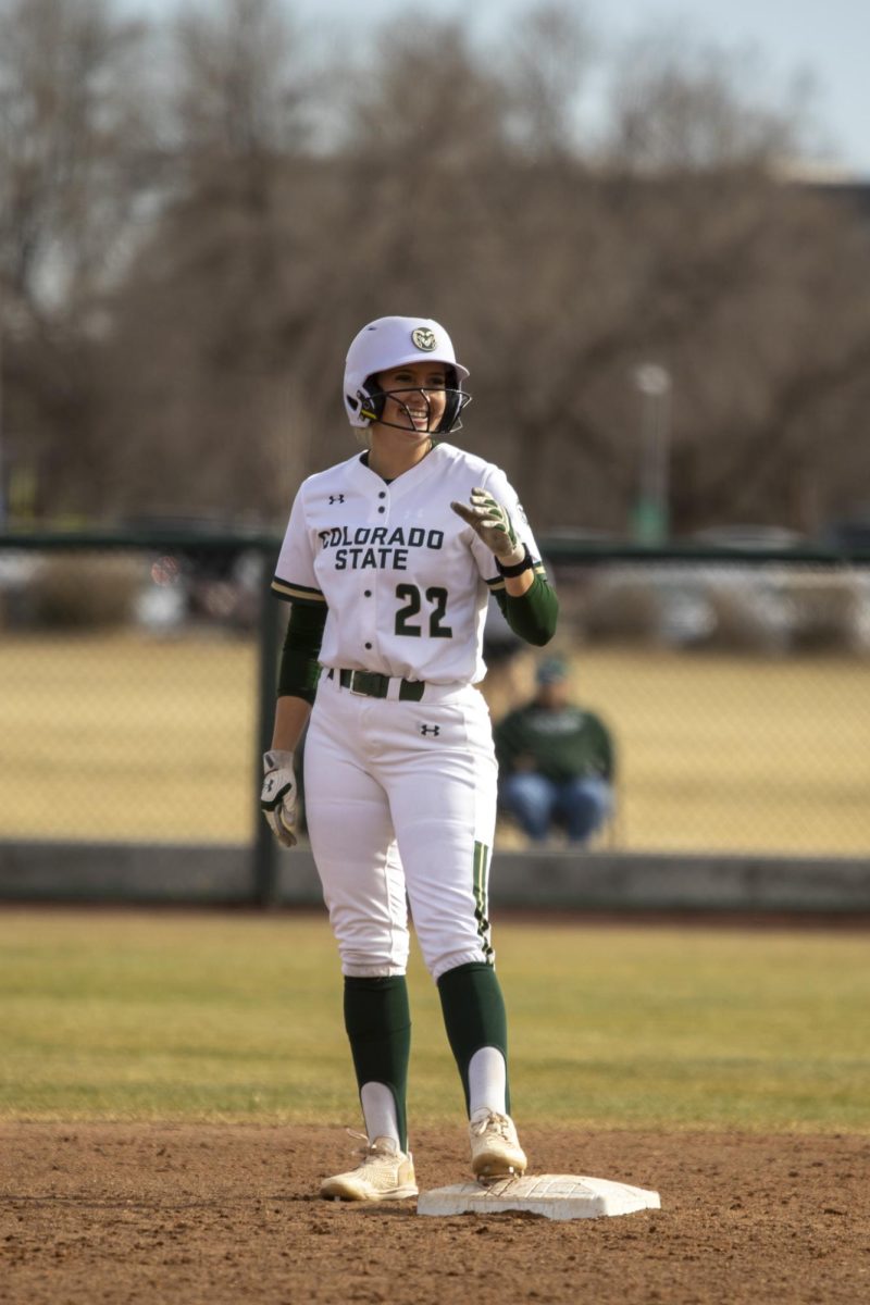 Kyra Smith (22) stands on third base celebrating her double hit while teamates cheer during game against UNC. The Rams won 5-1 at the CSU softball field on Feb. 28.