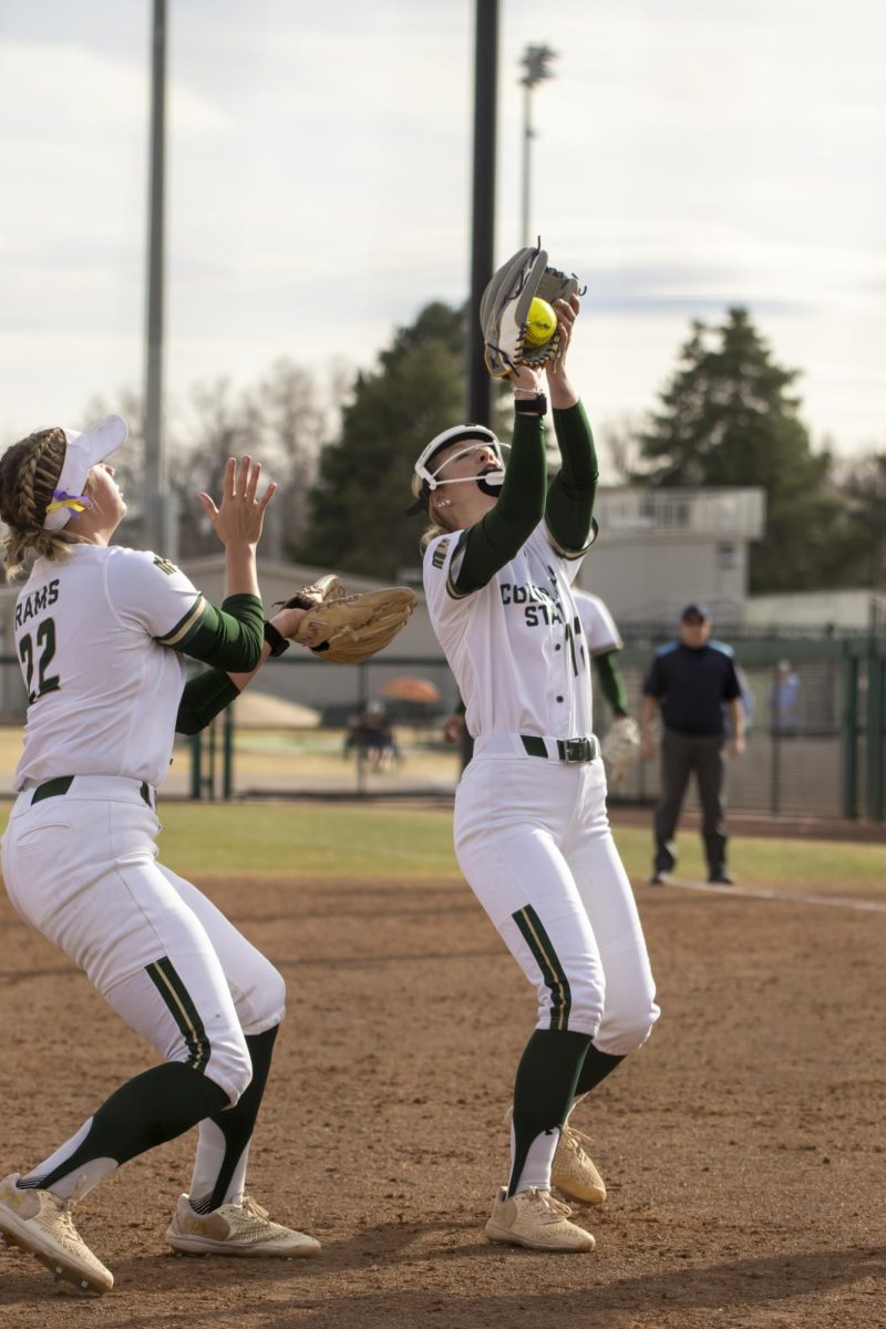 Pitcher Reagan Wick (12) catches a pop fly ball while teamate Kyra Smith (22) backs her up during game against UNC. The Rams won 5-1 at the CSU softball field on Feb. 28.