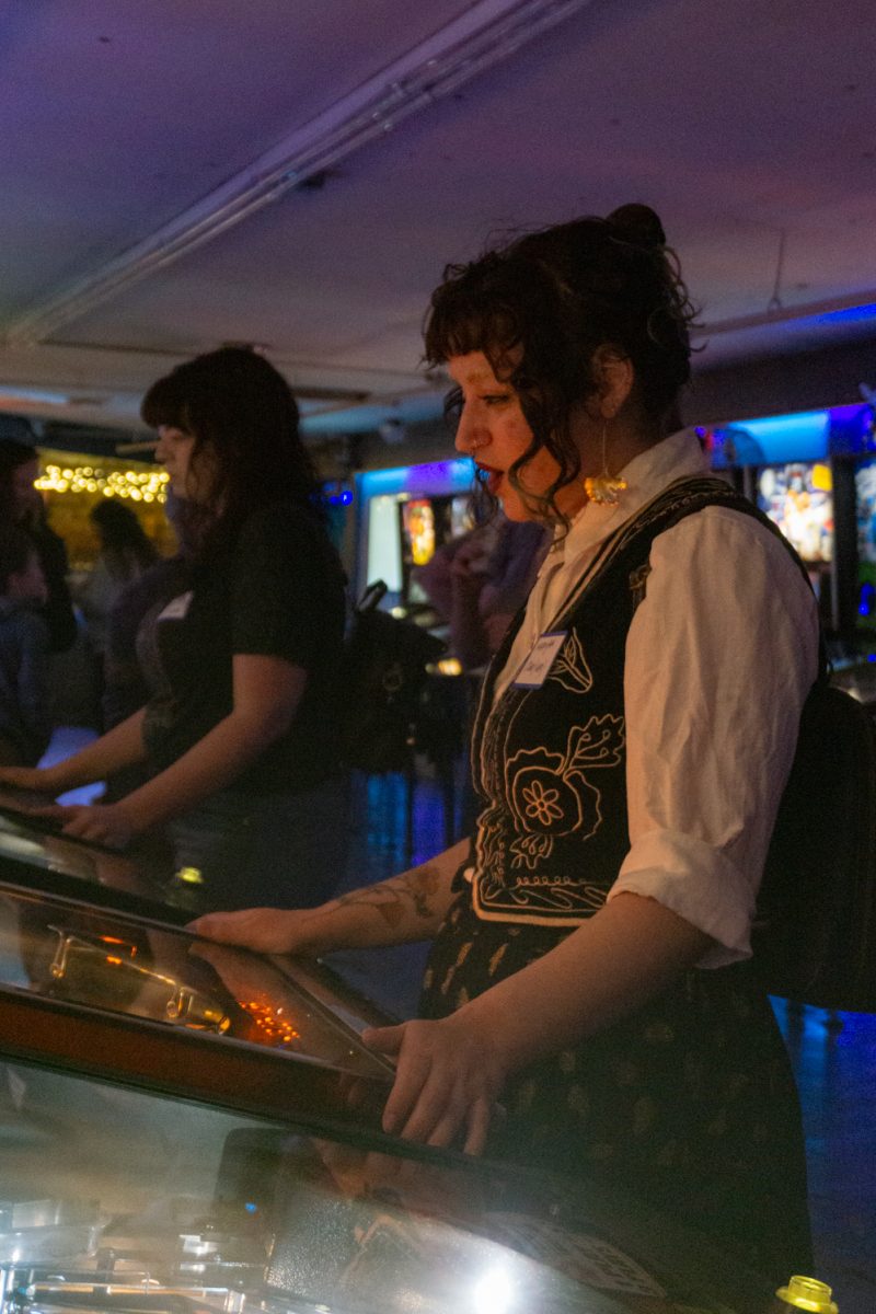 Maryam Aboellail reacts as she plays pinball at the women, trans, and femme league at Pinball Jones Feb 12. The league is meant to "help players grow their skills, connect with others, and enjoy pinball in a supportive setting" according to the Pinball Jones website.