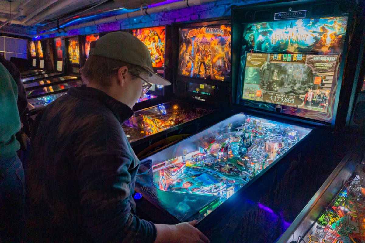 Cait Olde plays the Harry Potter pinball machine during the Women, Femme, Trans League Feb 12. Olde said that they haven't played pinball in about a year and that this is their first night playing again.