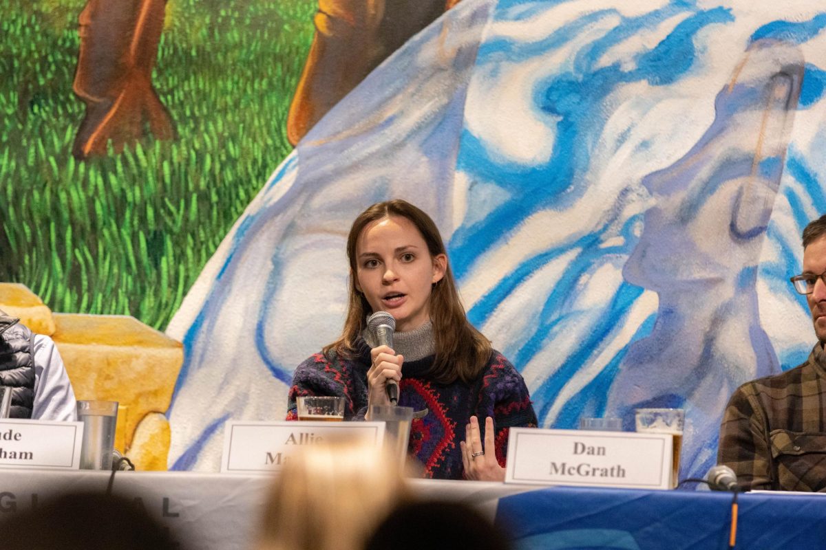 A woman holds a microphone in front of her face as she talks into it.