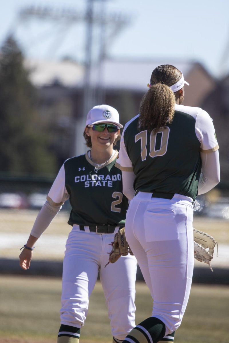 Jac Smith (2) congratulates teammate Jailey Wilson (10) on a play during Colorado State University’s first game against University of South Dakota March 7. The Rams won 4-2 at the CSU softball field.