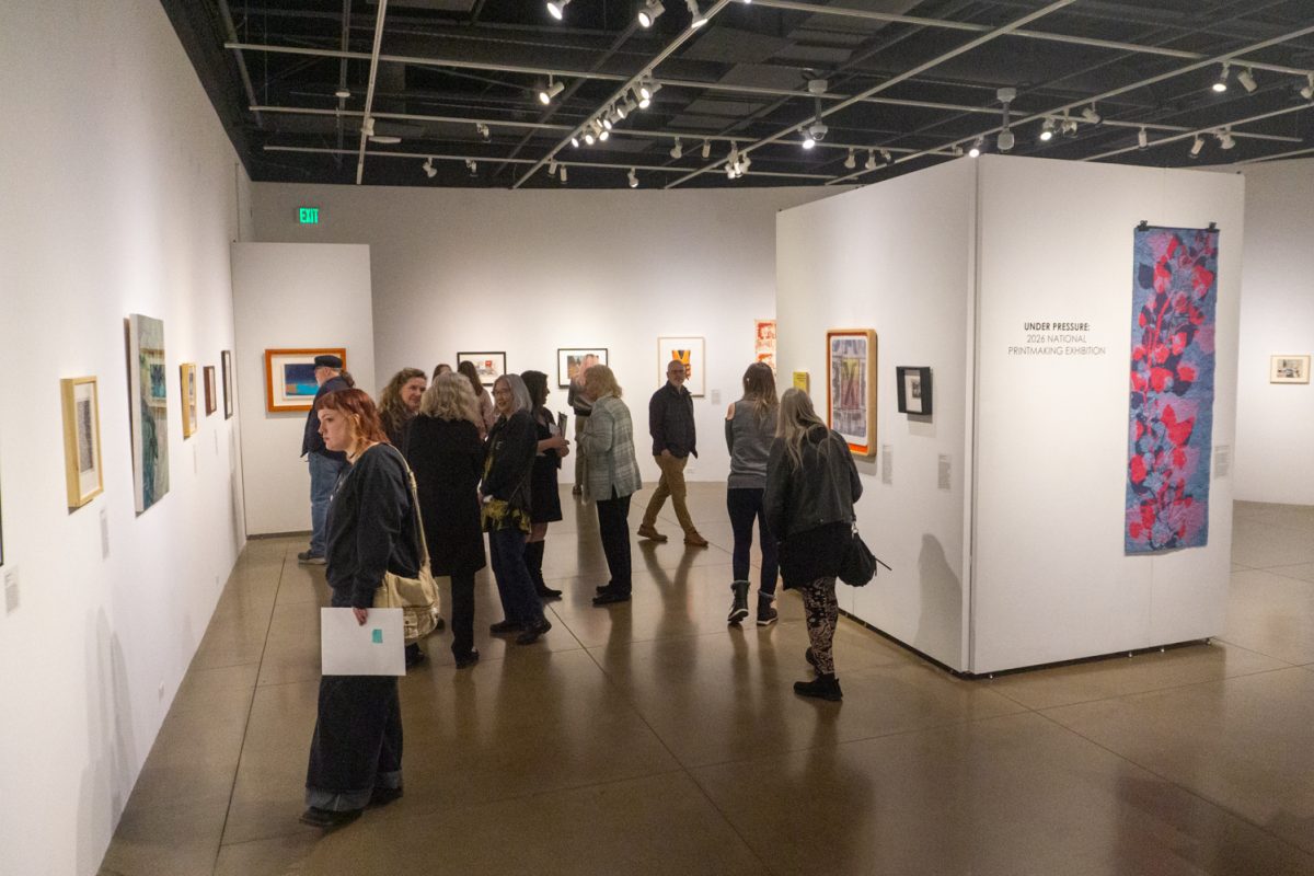 Event attendees, including artists who created pieces on display, view artworks at "Under Pressure," part of the 2026 National Printmaking Exhibition at The Lincoln Center March 7. The exhibition occurs biennially. Pieces in this showcase were selected by Colorado State University Associate Professor Johnny Plastini.