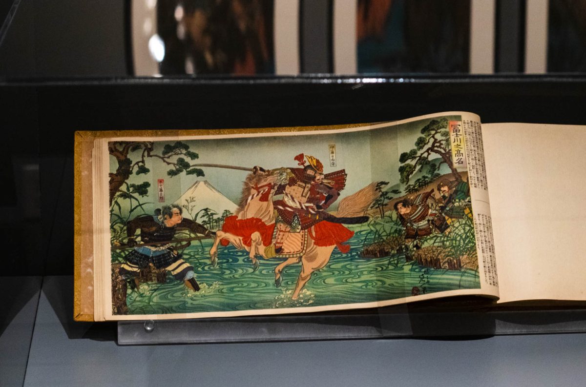 A page from "Yamatozakura: Kokushi Gacho" by Kokushi Meiga Kankokai displayed in a glass case at the Gregory Allicar Museum of Art March 8.