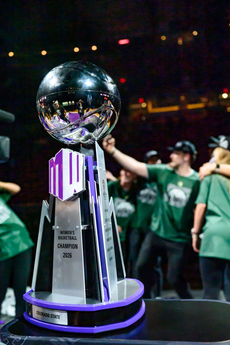 The Mountain West women's basketball trophy sits on a table as fans and teammates take photos to celebrate Colorado State University's women's basketball team's win March 10. 