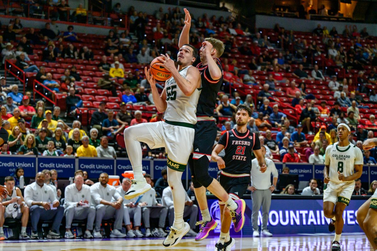 Colorado State University men's basketball guard Jevin Muniz (55) looks for a shot while facing pressure from Fresno State University guard Jake Heidbreder (3) during CSU's game against FSU in the Mountain West tournament March 11. Muniz led a burst of momentum that helped the team secure its 67-63 win against FSU. 