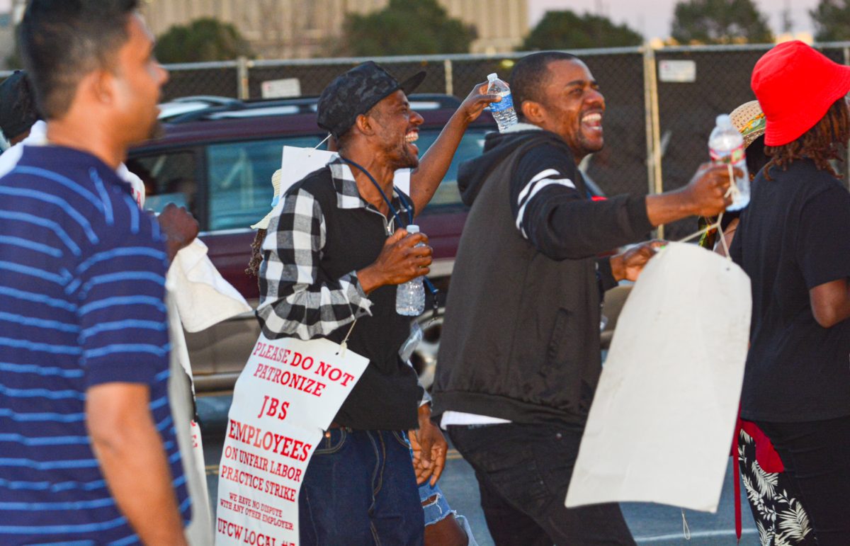 JBS workers laughing and enjoying the music while marching outside of the meat packing plant March 25. These workers are gathered day and night to fight for better wages and better working conditions, determined to make a huge company such as JBS hear them. 