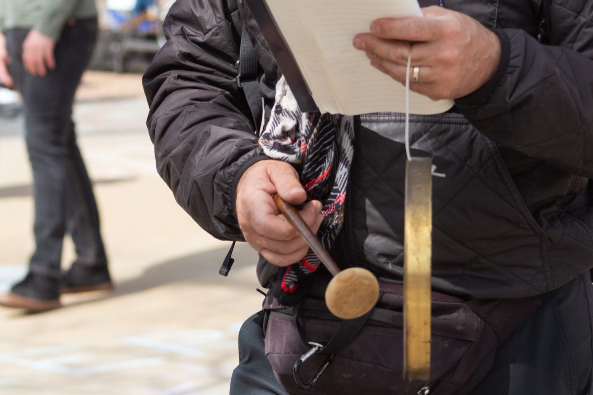 A supporter hits a gong during a group sing-along at the No Colonizers mutual aid event let by the Colorado State University Young Democratic Socialists of America, and CSU Students for Justice in Palestine in Oak Street Plaza Mar. 28. According to the CSU YDSA, the event aimed “to support local mutual aid groups aligned with addressing the current systemic issues that lead to the current stage of American fascism.”