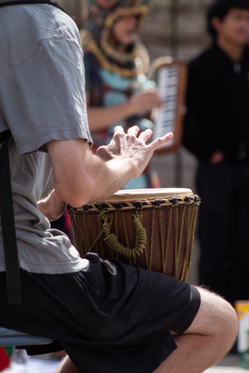A musician plays the bongos to accompany a guided group sing-along  at the No Colonizers mutual aid event let by the Colorado State University Young Democratic Socialists of America, and CSU Students for Justice in Palestine in Oak Street Plaza Mar. 28. According to the CSU YDSA, the event aimed “to support local mutual aid groups aligned with addressing the current systemic issues that lead to the current stage of American fascism.”