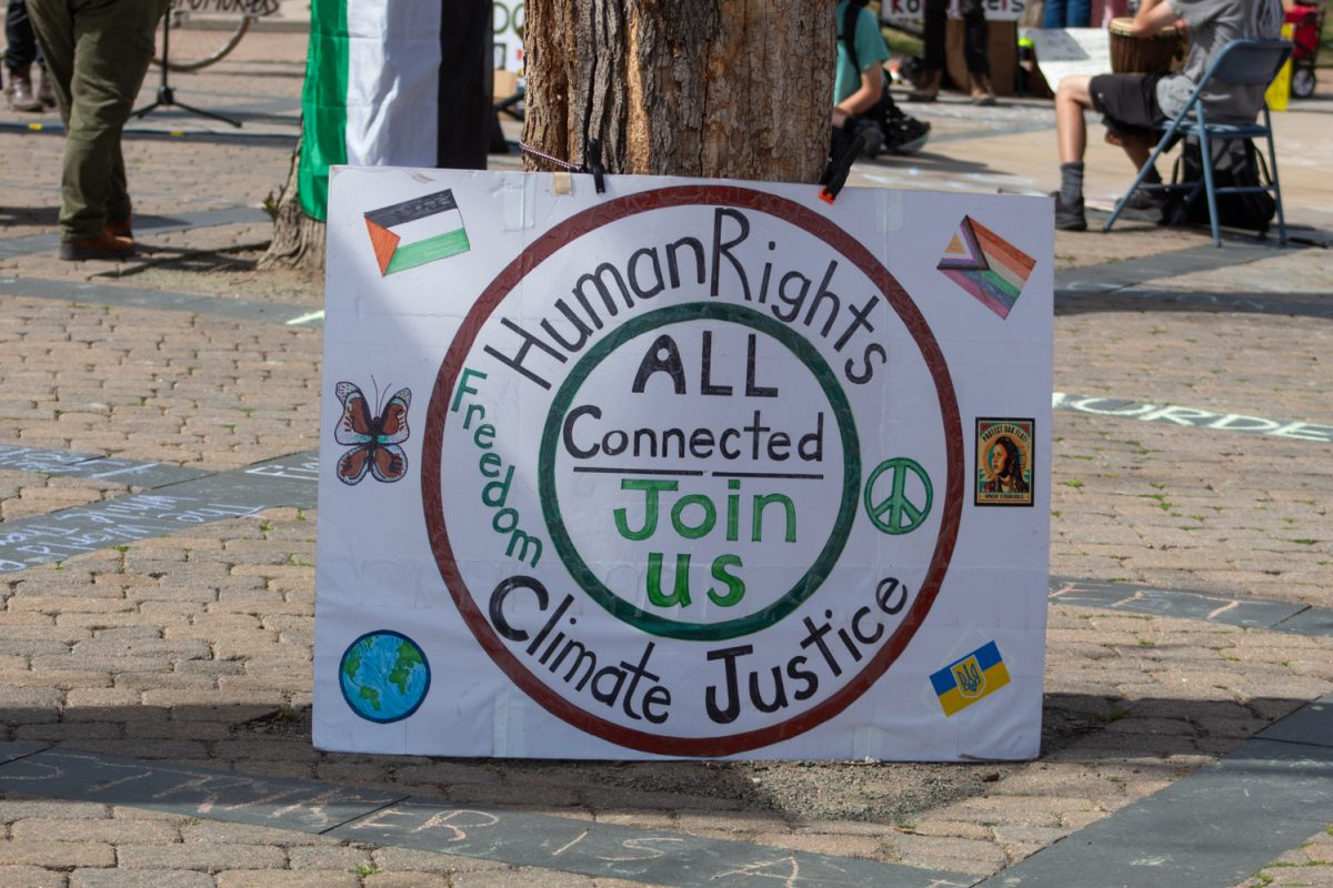 A sign leans against a tree in Oak Street Plaza during the No Colonizers mutual aid event let by the Colorado State University Young Democratic Socialists of America, and CSU Students for Justice in Palestine Mar. 28. According to the CSU YDSA, the event aimed “to support local mutual aid groups aligned with addressing the current systemic issues that lead to the current stage of American fascism.”