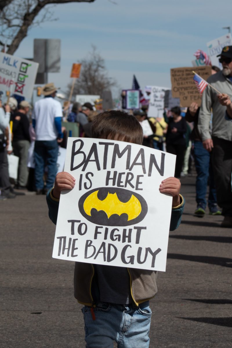 An anonymous young protester holds a sign while marching down North College Avenue March 28. This attendee was one of about 10,000 who showed up to attend the No Kings protest, where people in cities across the country expressed their dissatisfaction with the Trump administration. In Fort Collins, protesters attended a rally at Civic Center Park, listening to speeches, music, and shoutouts from community organizations, before marching through the city.