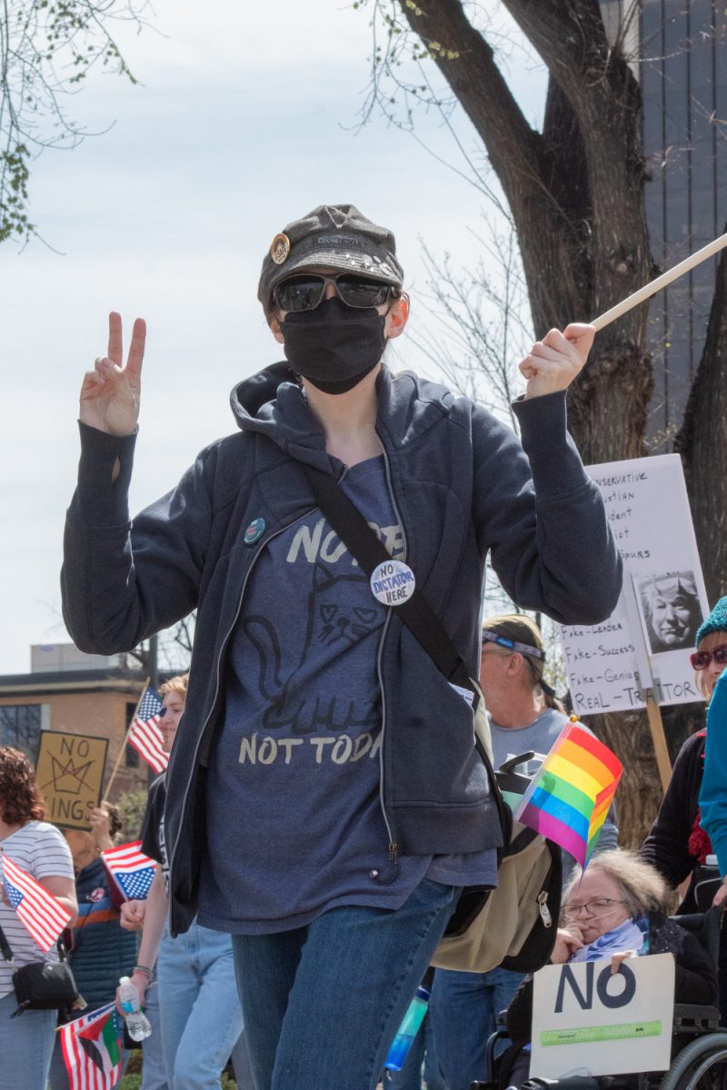 An anonymous protester poses for a picture while marching up North Howes street towards Civic Center Park March 28. This attendee was one of an estimated 10,000 who showed up to attend the No Kings protest, where people in cities across the country expressed their dissatisfaction with the Trump administration. “Love, not hate, that’s what makes America Great!” the protesters chanted.