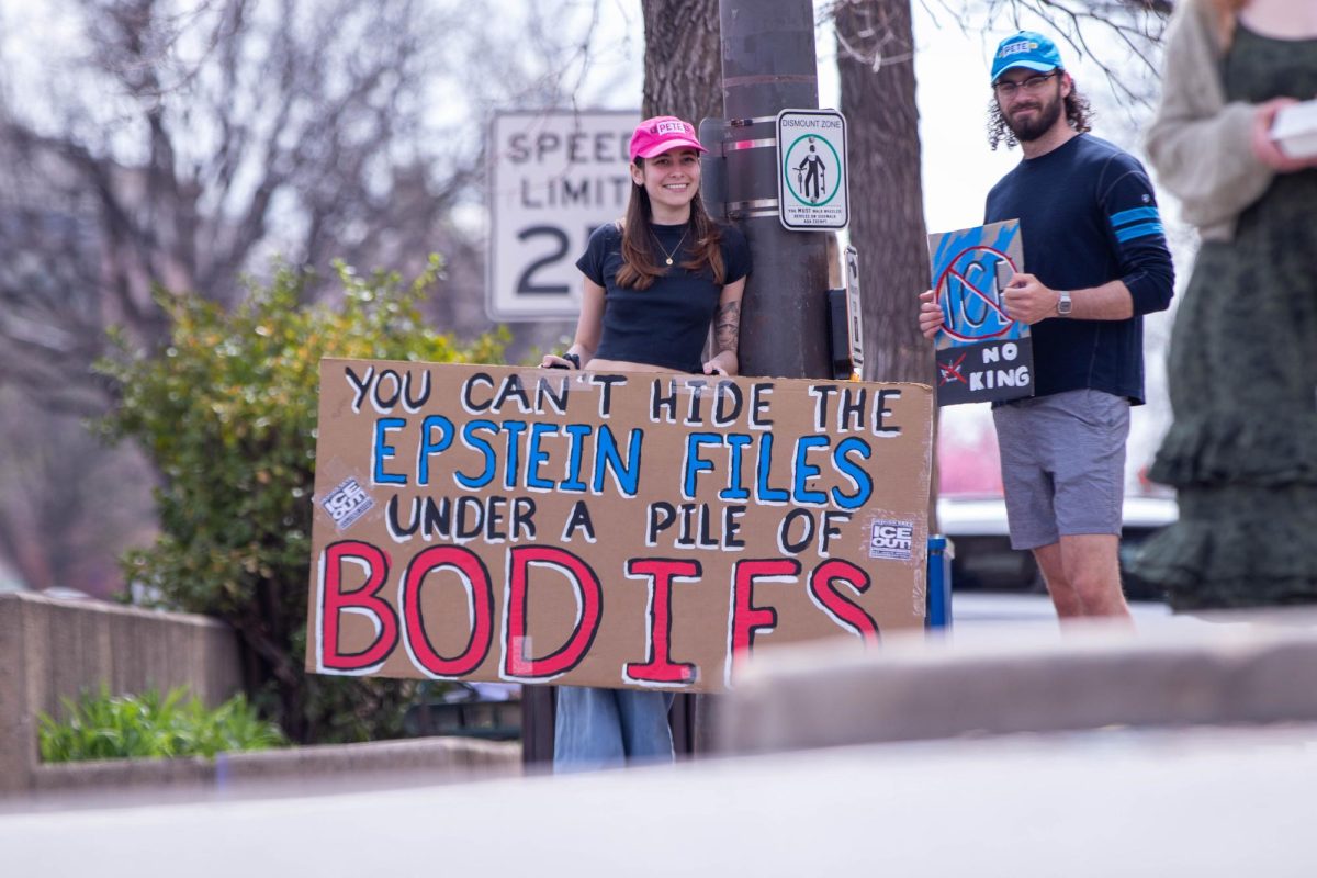 People protesting in Old Town Fort Collins on March 28. Holding a sign saying "you can't hide the Epstien files under a pile of bodies."