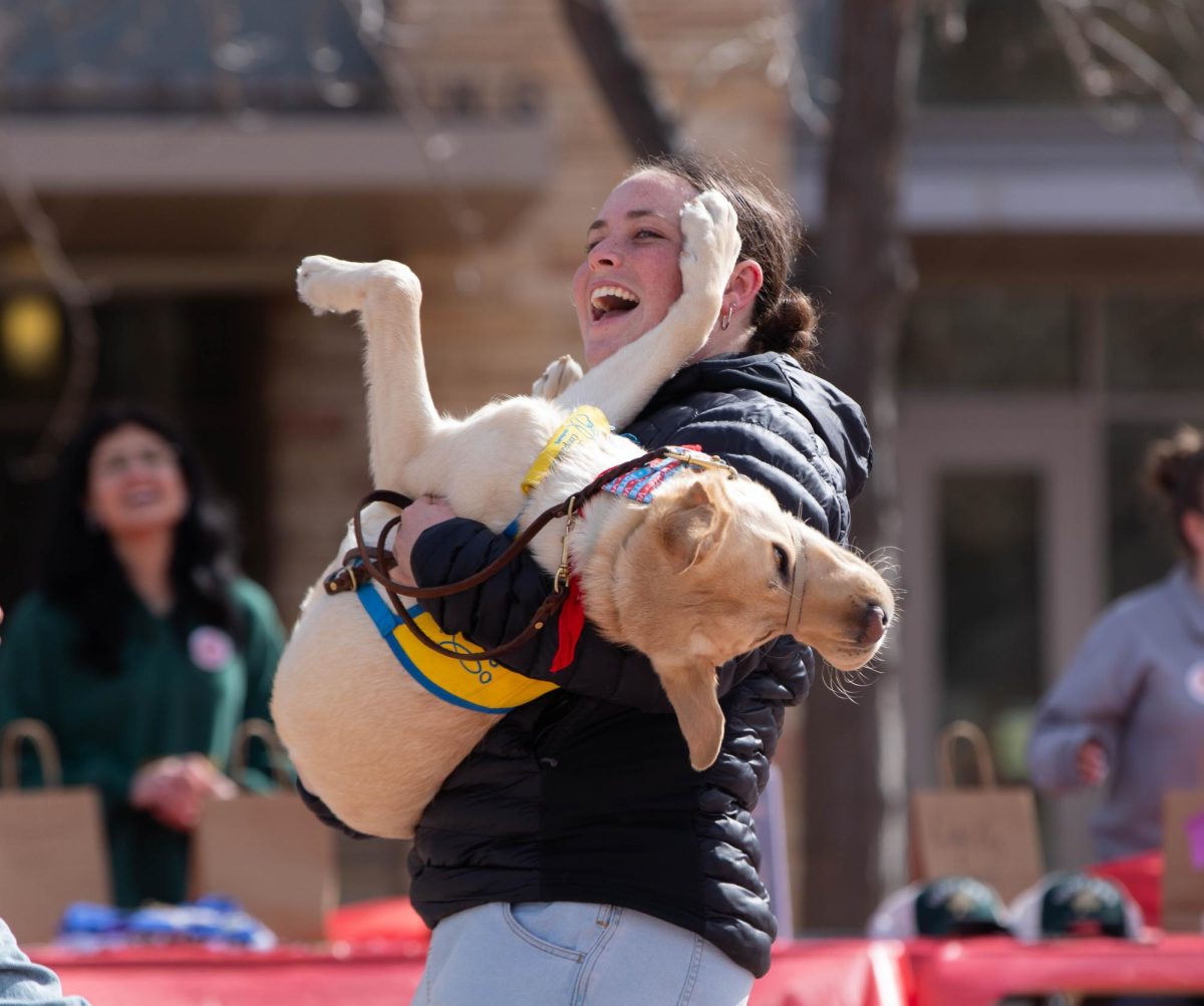 Associated Students of Colorado State University Elections Manager Emily Arnow and Filo, a canine companion she is training, dance to the music playing during the Saddle Up and Vote event at the Lory Student Center, March 10. "I just wat to support my peers and encourage people to vote." Said ASCSU member Abbie Farfan.
