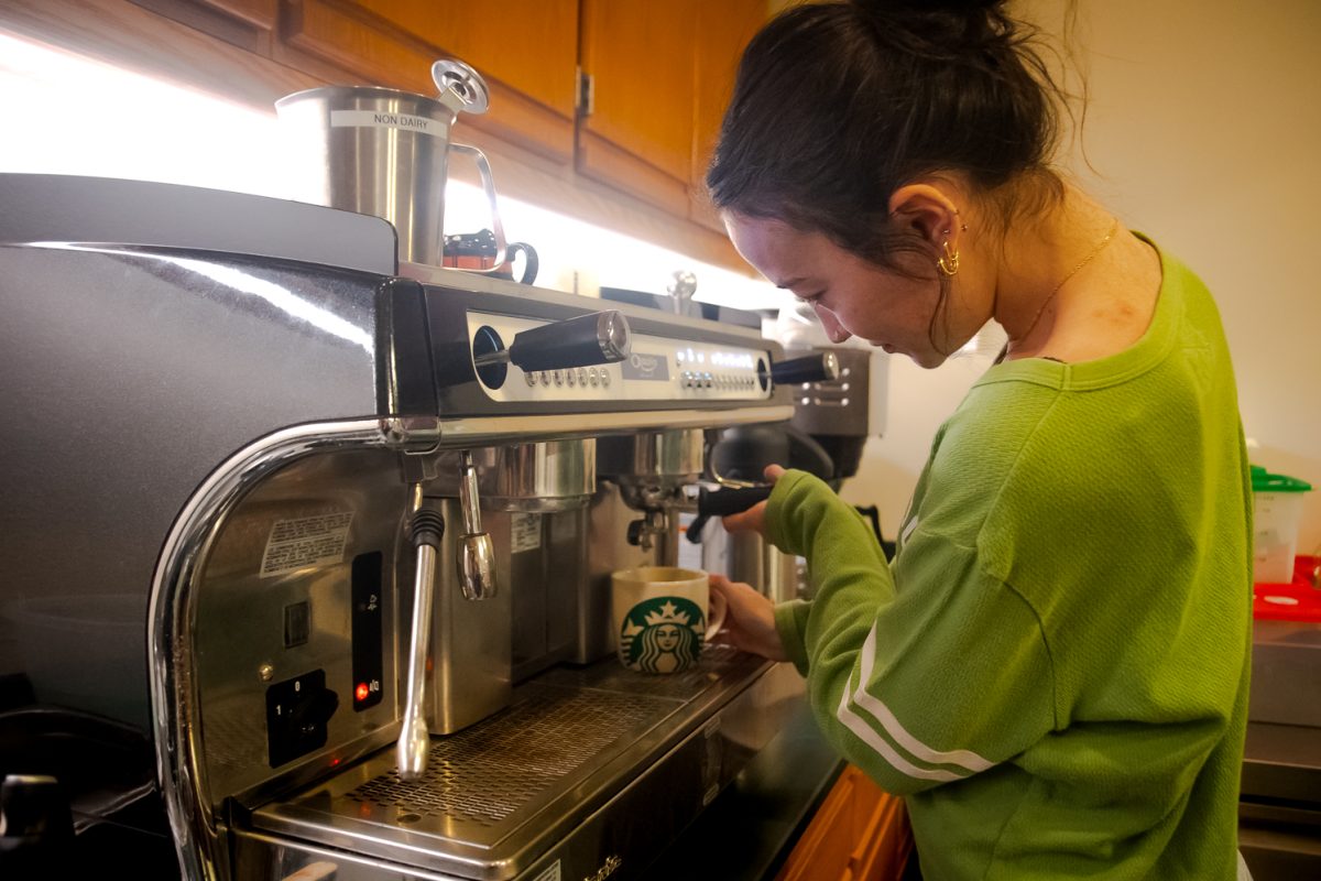Rylee locks the portafilter into place to begin the espresso extraction process April 1.