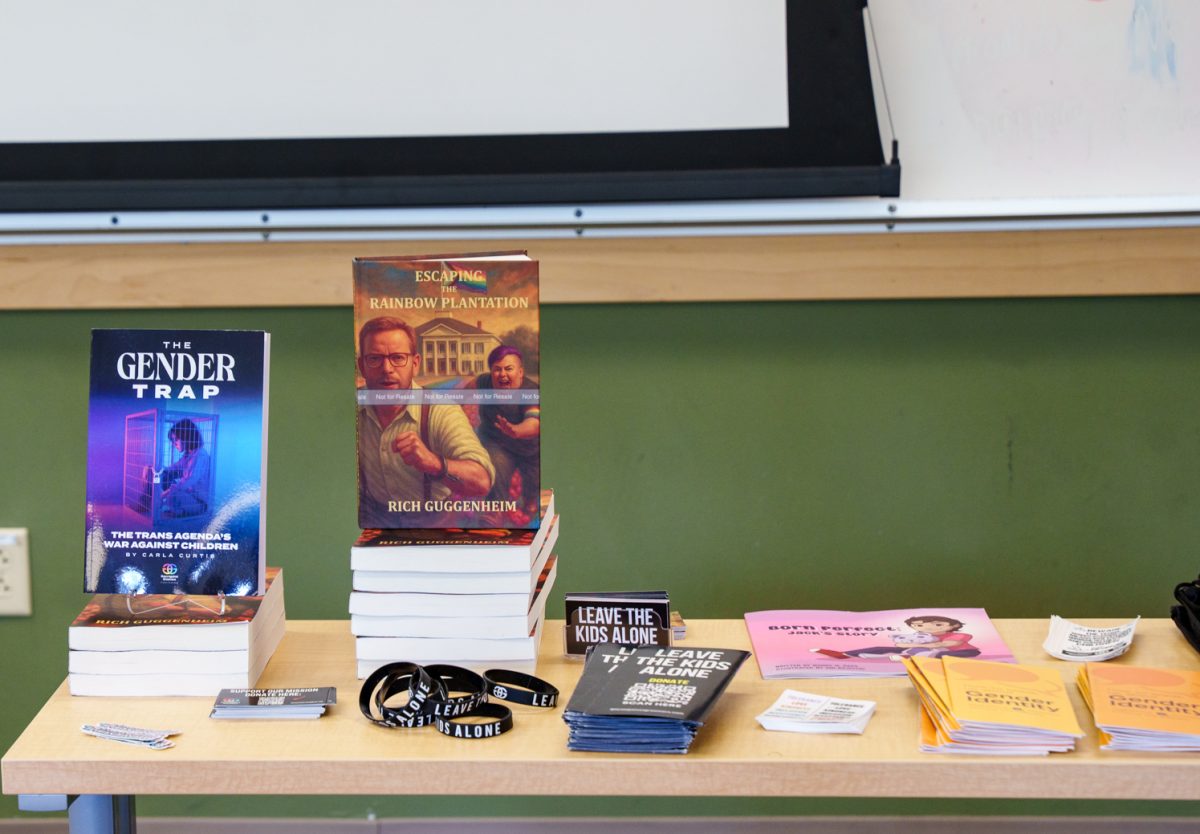 Books and merchendise brought by speakers from Gays Against Groomers sit on a table in Eddy Hall April 16.