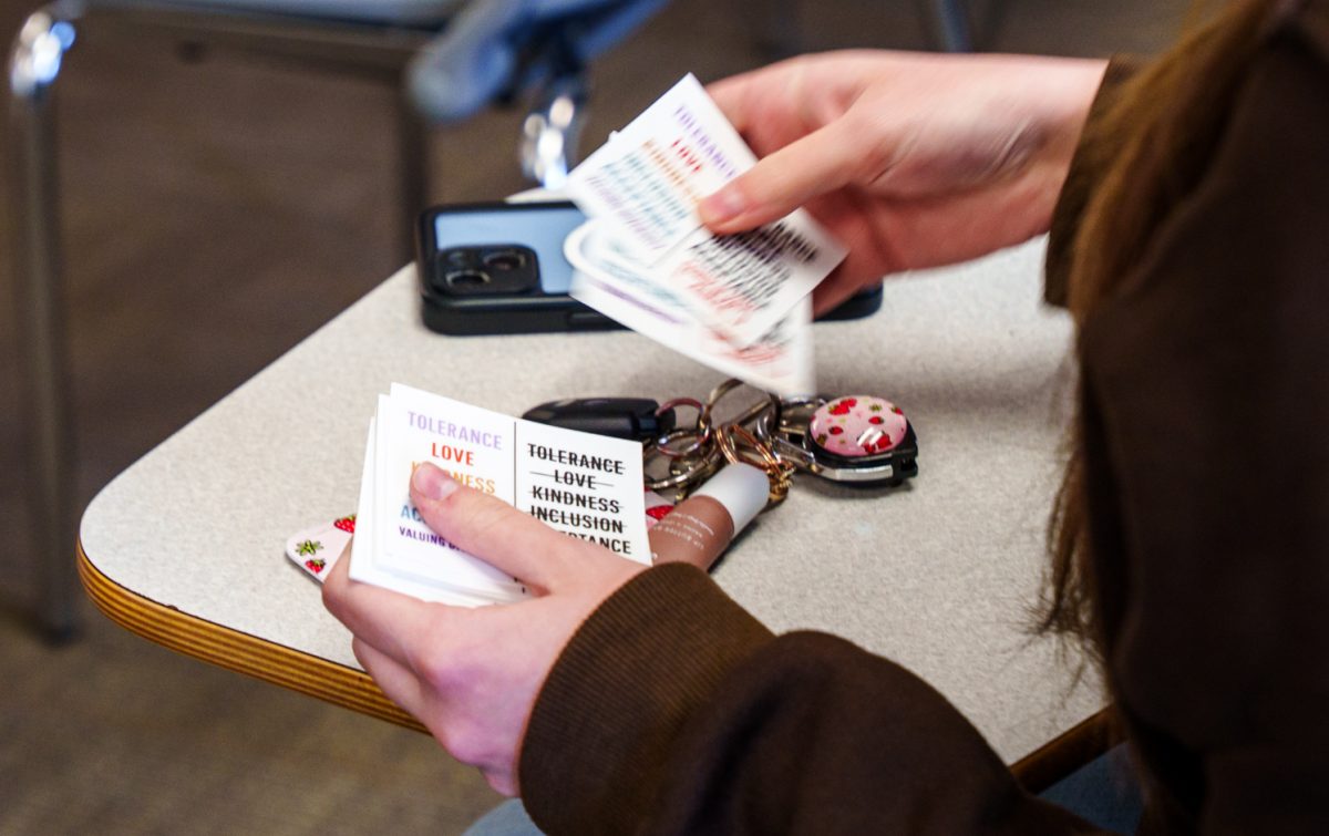 A Colorado State University Turning Point USA member looks through stickers brought by speakers for Gays Against Groomers April 16.