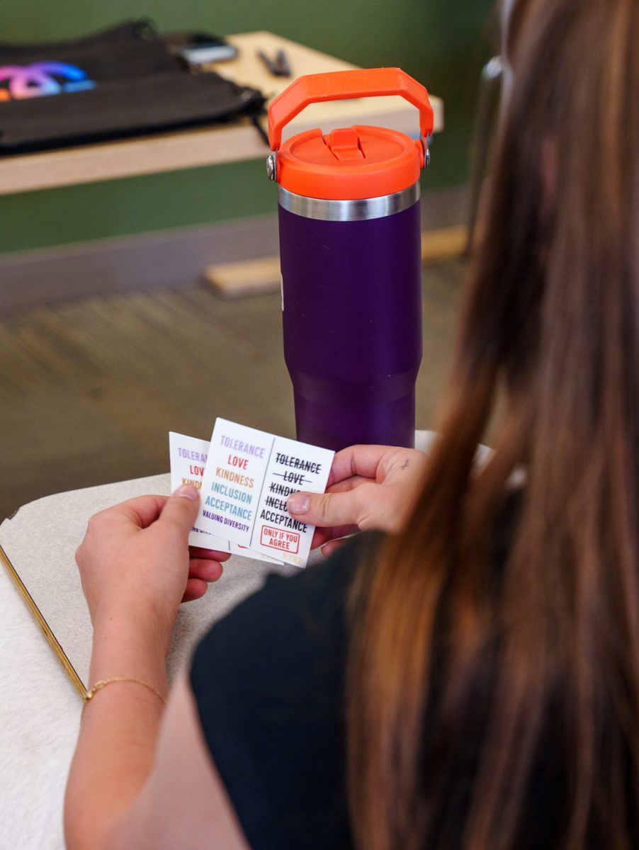 A Colorado State University Turning Point USA member looks through stickers brought by speakers for Gays Against Groomers April 16.