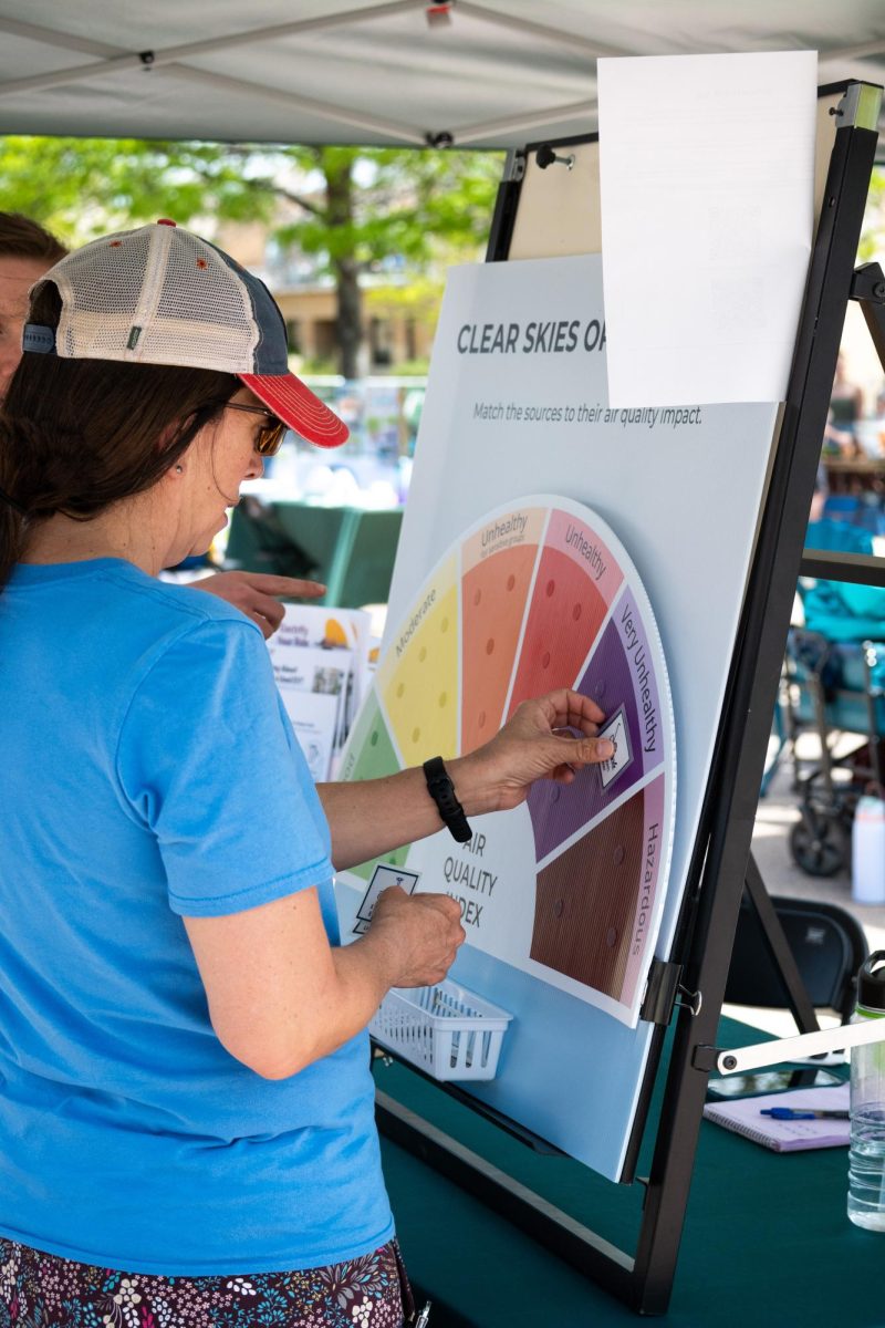 An attendee interacts with Climate Smart Future Ready's board about air quality index during Colorado State University's Earth Day Festival on the Lory Student Center Plaza April 22.