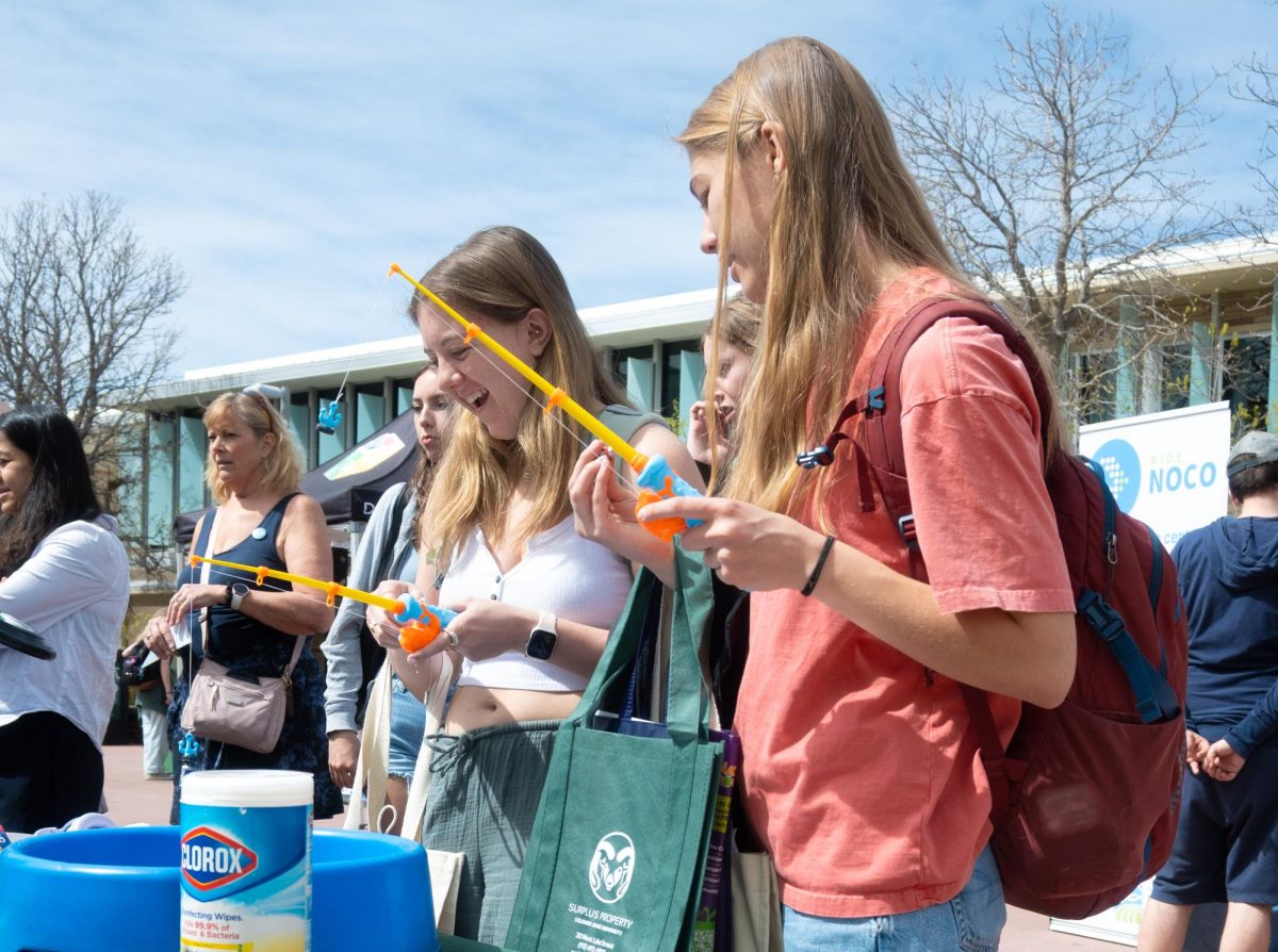 Avery Kingsbury and Brooke Wageman participate in an interactive game on the Lory Student Center Plaza at Colorado State University Facilities Management's table for the Earth Day Festival April 22 .