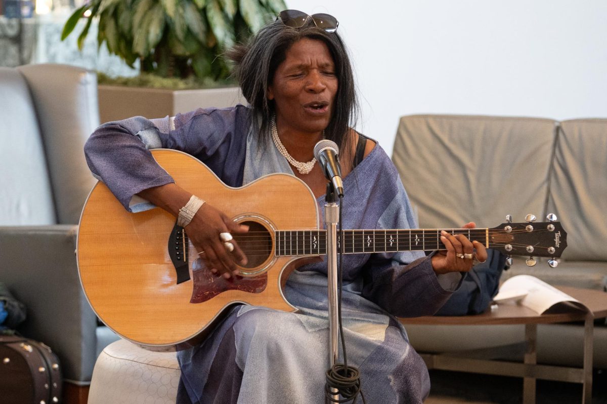 Louise Cutler, the curator of the event and herself an artist in many mediums, performs a song on the guitar, April 27. Cutler believes in making art accessible to all, including younger generations who may often feel excluded. “A community can’t exist without these kind of events. It just would be dead and boring, and I think everybody would just dry up like a prune, because these events feed our souls,” Cutler said. “This is what breathes life into us. I’m a firm believer in community and you can’t have community without having events like this.”