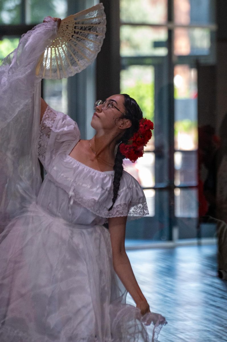 Veronica Wilson, a Baile Folklo Rico dancer, performs her piece from behind glass, as if a piece of art on display, her exhibition for the evening of art and live experiences held at the foothills mall, April 24. Wilson says she uses her art to tell stories and to express her feelings around herself and her religion. “When I did my dance I wanted to show a story in it,” Wilson said. “At the beginning I was hiding my face, hiding myself, and I think it was a form of shame. As I’m dancing it’s a way of me learning that I don’t have to hold onto that shame, and I can give it to [God]. And so at the end I am able to reveal myself.”